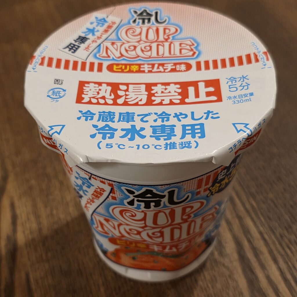 Top of a Hiyashi Cup Noodle lid showing the Japanese instructions 'boiling water prohibited,' 'cold water five minutes,' and a recommended water temperature of 5 to 10 degrees Celsius.
