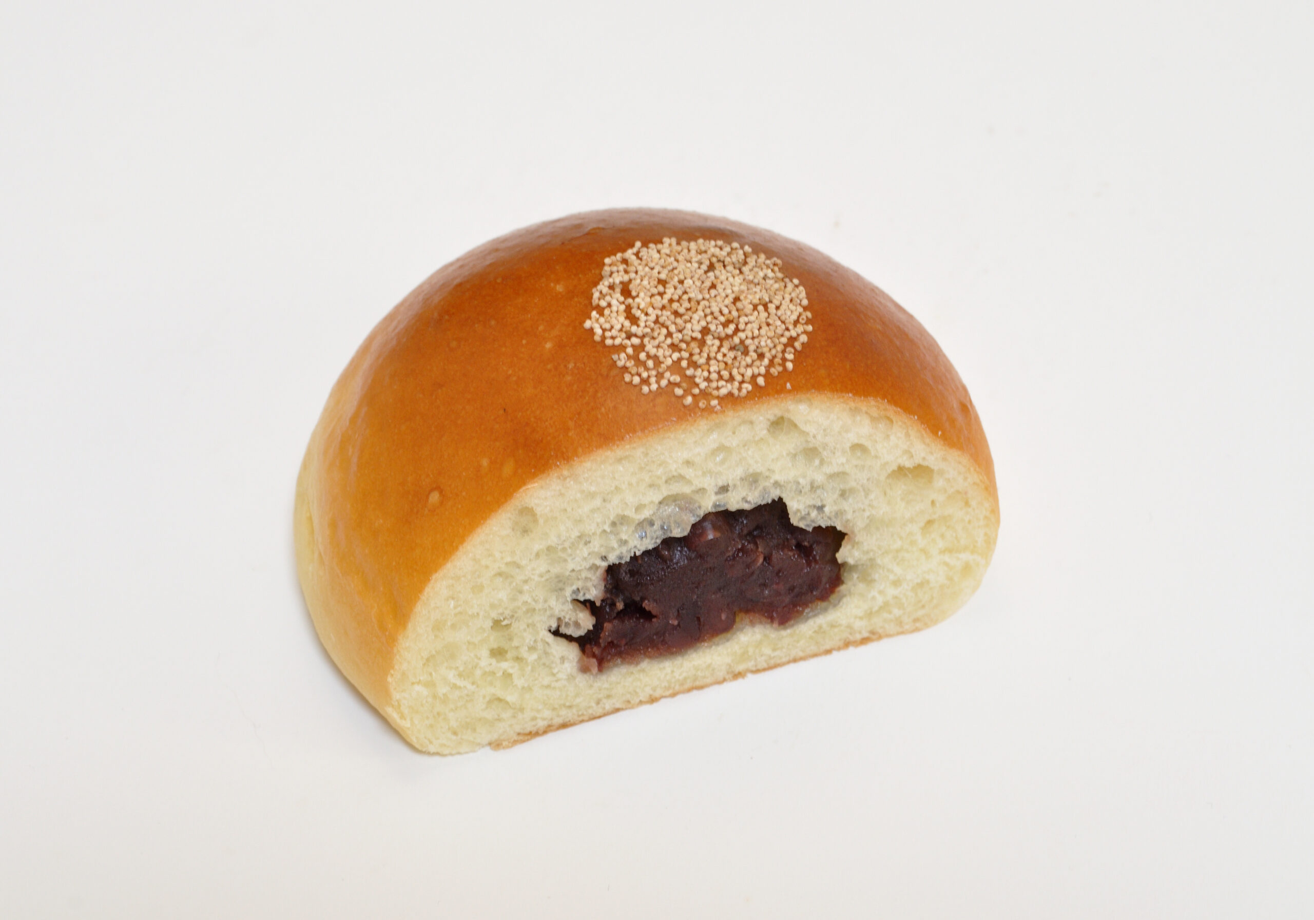 A Japanese anpan sweet bun cut open to show red bean paste